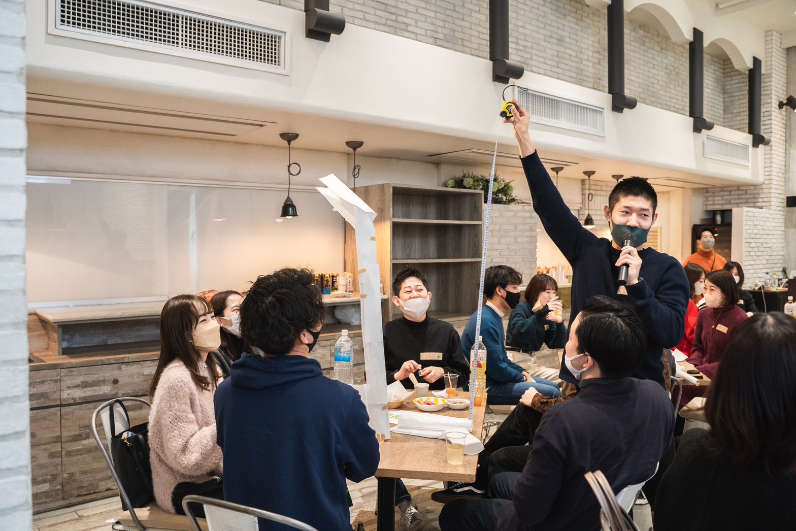 紙を使ったミニゲームを盛り上げる新福さん＝提供
