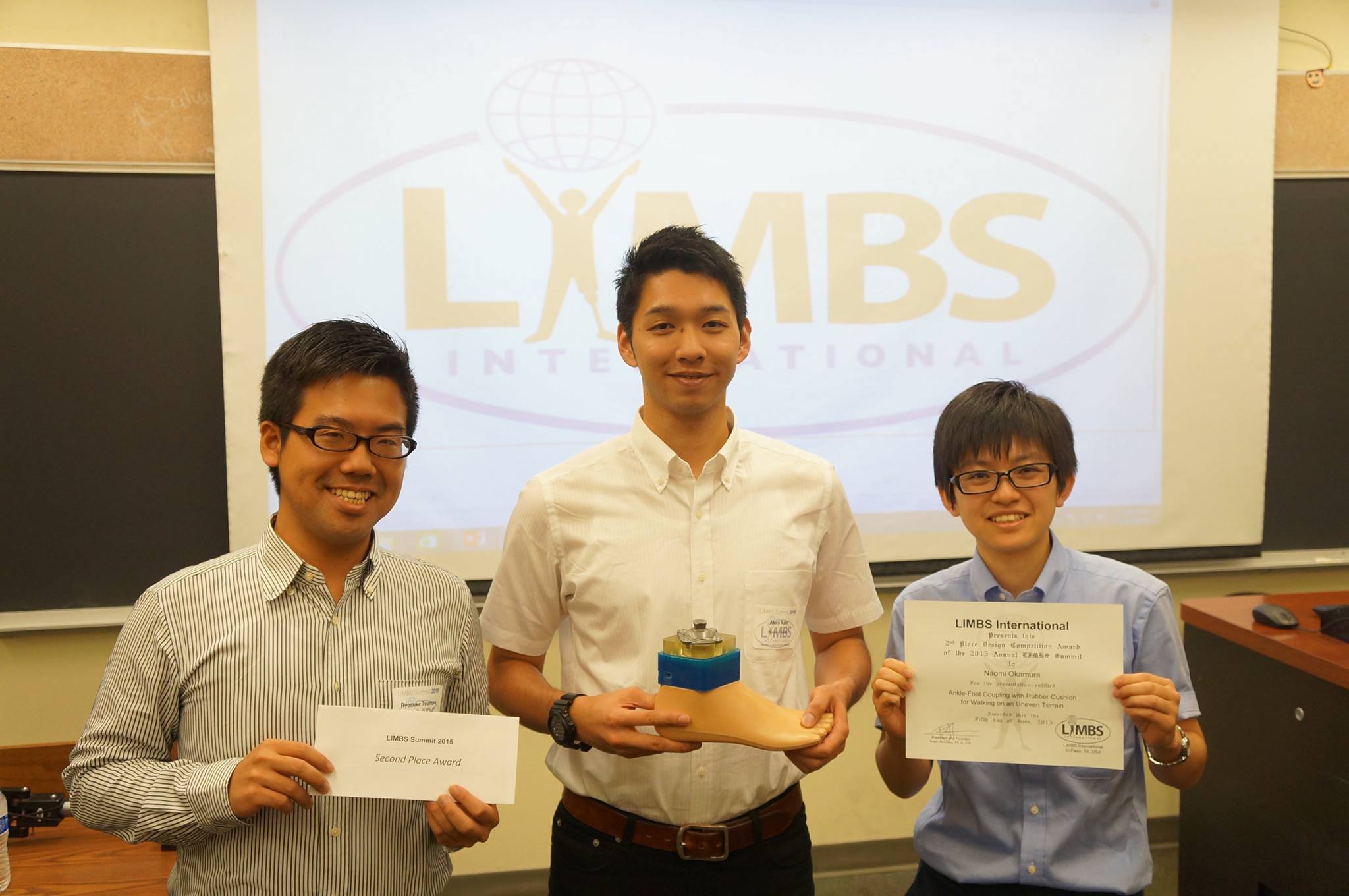 義足の研究機関より表彰された研究所メンバーと岡村さん（右）
