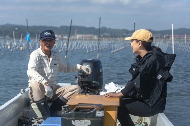 海苔漁師さんと。この人の元で、3人の若者が移住して漁師として働いている(写真・本人提供)